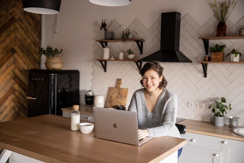 young-woman-using-laptop-in-kitchen-4049786